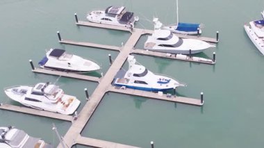 Avustralya, Port Douglas 'taki bir marinaya yanaşmış tekneleri görüntülüyor. Sakin sular ve berrak gökyüzü sakin bir atmosfer yaratır.