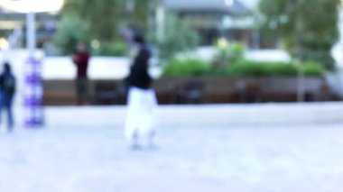 Kamu meydanında yürüyen bulanık figürler