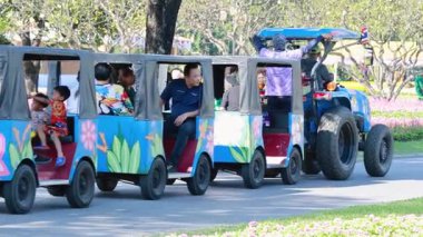 Ziyaretçiler çiçek bahçelerinde traktör yolculuğunun keyfini çıkarıyorlar.