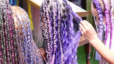 Phuket caddesinde canlı bir şekilde örülmüş renkli saç uzantıları, karmaşık desenler ve canlı renkler.