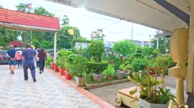 İnsanlar Kanchanaburi tren istasyonunda gün ışığında canlı ve bitkisel bir yoldan yürüyorlar.