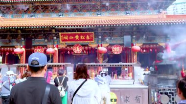 Ziyaretçiler namaz kılar ve tütsü dağıtırlar.