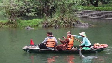 Turistler sakin bir nehirde sakince kürek çekiyorlar.