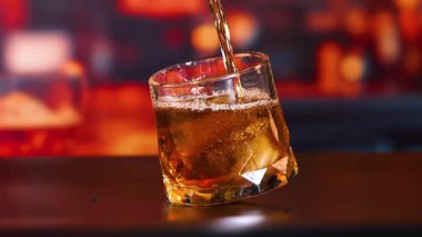 Viski buzlu bir bardağa dökülüyor.
