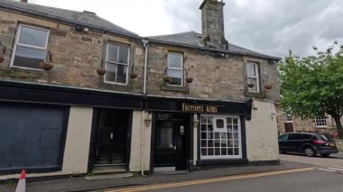 Yayalar tarihi bir İskoç barının etrafında dolaşıyorlar.