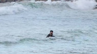 Okyanusta pratik yapan iki sörfçü.