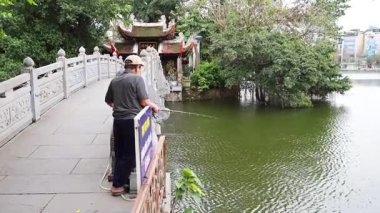 Tapınağın yakınındaki köprüde balık tutan adam