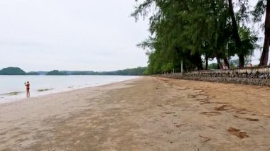 Tayland, Krabi 'de sakin bir plaj boyunca huzurlu bir yürüyüş.