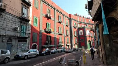 Arabaları ve yayaları olan kalabalık bir cadde.