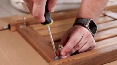 Eller ahşap mobilyaları tornavida kullanarak monte ediyor. Parlak ışıklandırma, Gold Coast 'ta ayrıntılı işçiliği ön plana çıkarıyor