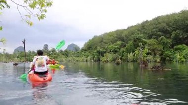 Kayakçılar yemyeşil çevredeki berrak suları keşfeder.