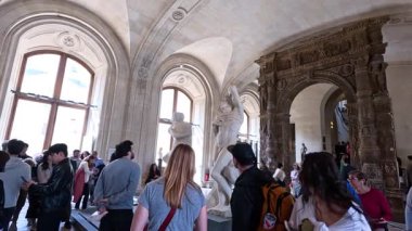 Louvre Müzesi 'ndeki bir koridoru keşfeden ziyaretçiler