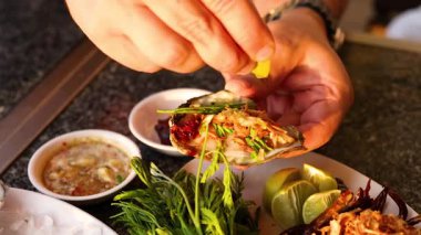 Eller istiridyeleri otlar ve soslarla hazırlıyor.