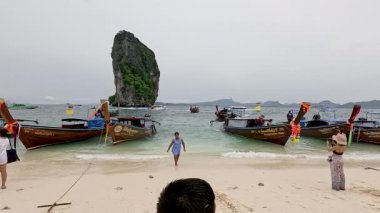 Turistler, uzun kuyruklu tekneleriyle Krabi sahilinin tadını çıkarıyorlar.