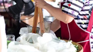 Manüel ütü kullanarak erişte yapan biri.