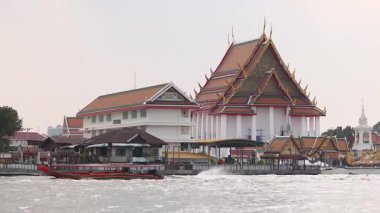 Tekne Chao Phraya Nehri 'ndeki tapınağın önünden geçiyor.