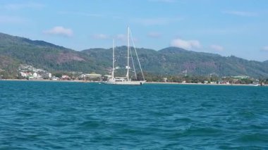 Açık gökyüzünün altında Ko Racha Yai, Phuket yakınlarındaki okyanusta sakin bir yelkenli ve balıkçı teknesi manzarası.