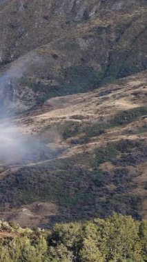 Queenstown, Yeni Zelanda 'daki tepelerin üzerinde sis olan sakin bir dağ manzarası. Doğal gün ışığında yakalandılar.
