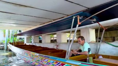 Bangkok 'un yüzen pazar kanallarında uzun kuyruklu tekne geziniyor.