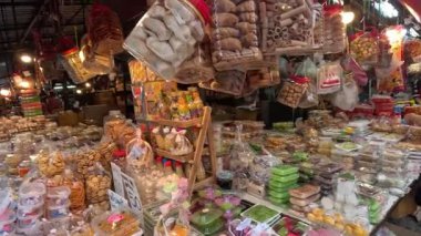 Çeşitli ikram ve müşterilerle renkli büfeler.