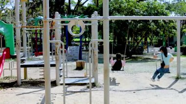 Çocuklar Rama 9 Parkı 'nda salıncakların keyfini çıkarıyor.