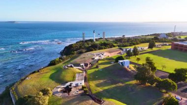 İnsansız hava aracı görüntüleri Bellarine Yarımadası 'nı yemyeşil, tarihi deniz feneri ve açık gökyüzü altında geniş okyanus manzaralarıyla yakalar.