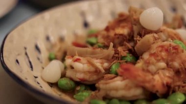 İçinde karides ve sebzeler olan lezzetli bir yemek.