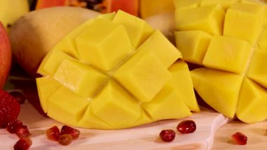 Dilimlenmiş mango ve çeşitli meyvelerin yakın çekimi.