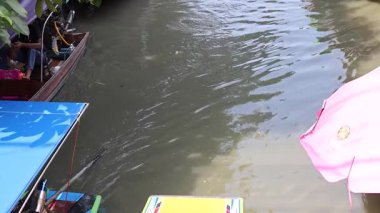 Tekneler canlı bir pazarda bir kanalda yol alırlar.