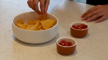 Ellerin kasede salsa sosu ekliyor.