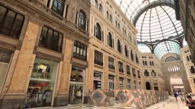 Turistler büyük bir mimari galeride yürüyorlar