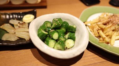 Çubuklar yeşil sebzeleri kasede karıştırıyor.