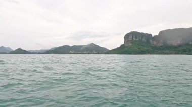 Uzak dağlarla okyanus ve ada manzarası