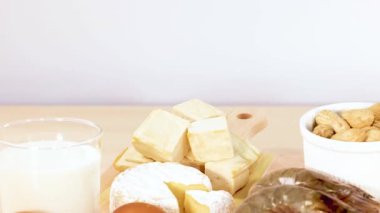 Ceviz, yumurta ve süt ürünleri de dahil olmak üzere çeşitli protein zengini gıdalar ahşap bir masa üzerinde ustalıkla düzenlenmiştir.