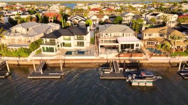 İnsansız hava aracı günbatımında Gold Coast 'un sakin nehri boyunca lüks liman arazilerini yakalıyor. Mimari zarafet ve sakin çevreyi vurguluyor.