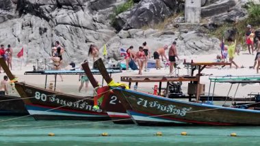 Phuket 'te canlı bir sahil, tekneleri ve güneşin tadını çıkaran insanlar. Canlı renkler ve dinamik hareketler yaz atmosferini yakalar