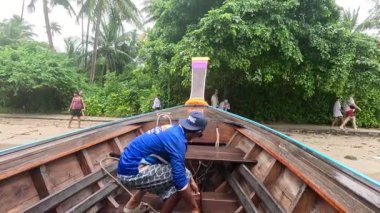 Adam Krabi sahilinde uzun kuyruklu tekne hazırlıyor.