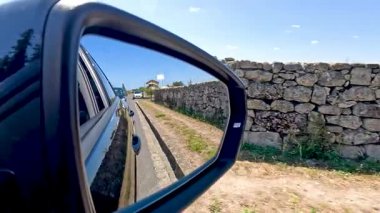 Taş duvar boyunca giden araba.