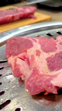 Bangkok 'ta Kore usulü mangalda pişmiş et. Parlak ışıklandırma mermer ve cızırtılı eylemi vurgular