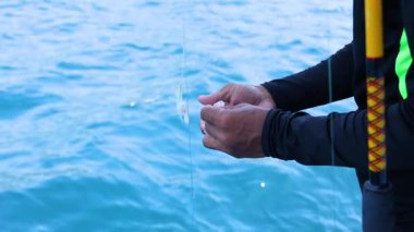 Biri Phuket, Tayland 'da açık mavi suları ve parlak gün ışığıyla bir teknede balık yemi hazırlıyor.