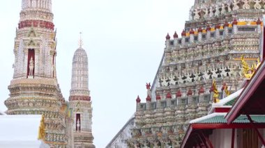 Wat Arun 'un süslü kuleleri gün ışığında ele geçirildi, Bangkok, Tayland' da karmaşık mimari ve dingin atmosfer sergileniyor.