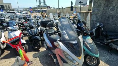 Kalabalık bir alana park etmiş bir sürü motosiklet var.