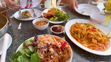 Bir masada paylaşılan çeşitli deniz ürünleri yemekleri.