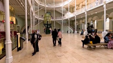 İnsanlar geniş müze salonundaki sergileri keşfediyorlar.