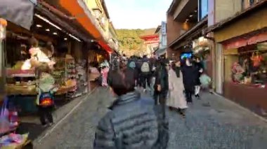 Turistlerin ve geleneksel dükkanların olduğu kalabalık bir sokak.