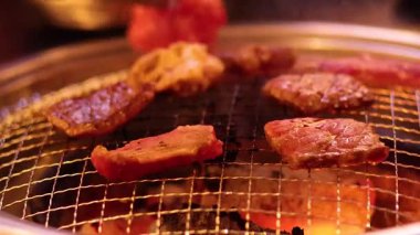 Barbeküde ızgara et ve maşa.