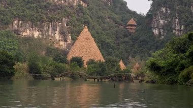 Nehir, kulübeler ve bereketli arazide köprü.