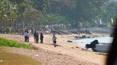 İnsanlar Pattaya sahilinde yürüyor ve toplanıyor.
