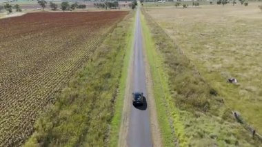 Kırsal bir yolda bir araba yavaş hareket eder.