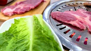 Canlı bir Bangkok ortamında taze marulla ızgarada cızırdayan et. Parlak ışık, canlı yemek atmosferini güçlendirir.